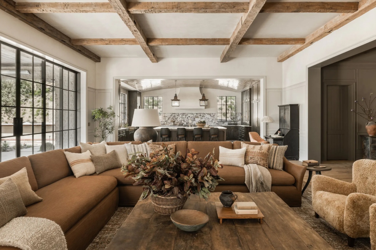 Bước vào căn nhà nằm tại bang California này, mọi người sẽ chú ý đến phòng khách đầu tiên. Phòng khách lấy tông nâu từ chất liệu gỗ làm chủ đạo để tạo sự ấm áp cho căn nhà. Gia chủ sử dụng hoa giả để mang lại sức sống cho căn phòng.