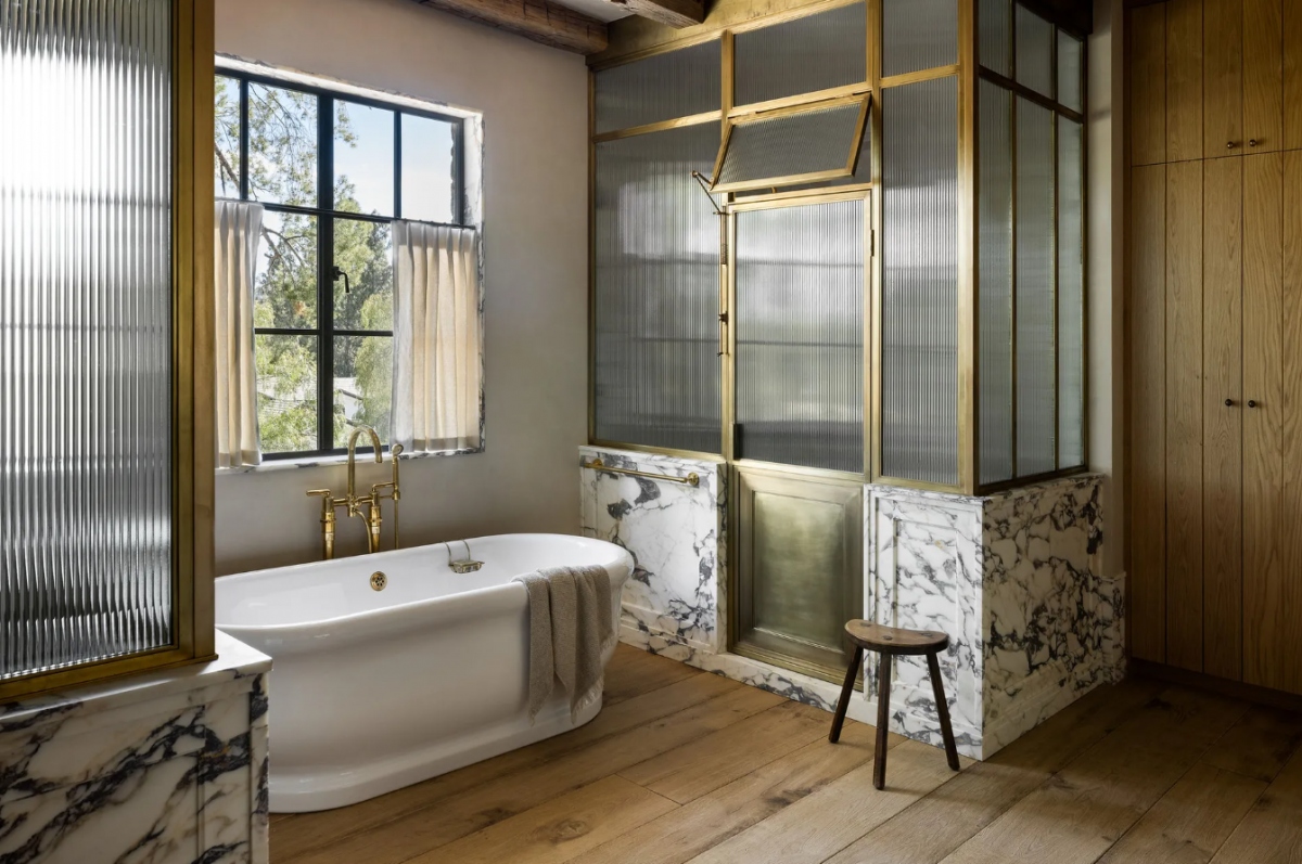 Trong phòng tắm, bồn tắm được đặt ở vị trí hướng vườn. Sàn lát gỗ khiến căn phòng trở nên sạch sẽ hơn.