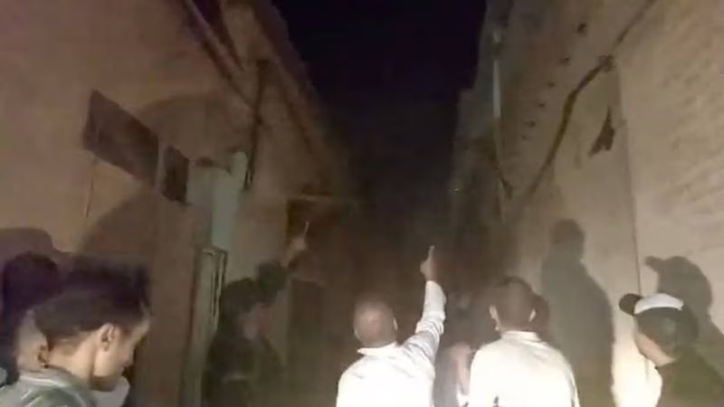 Một số người đang kiểm tra thiệt hại do động đất gây ra. Ảnh: Reuters.
