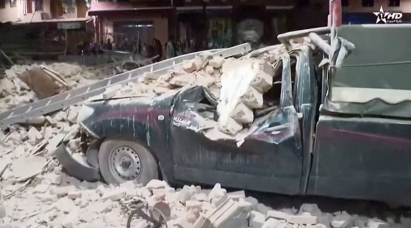 Chiếc ô tô bị bẹp rúm do gạch đá từ các tòa nhà rơi xuống. Ảnh: Reuters.