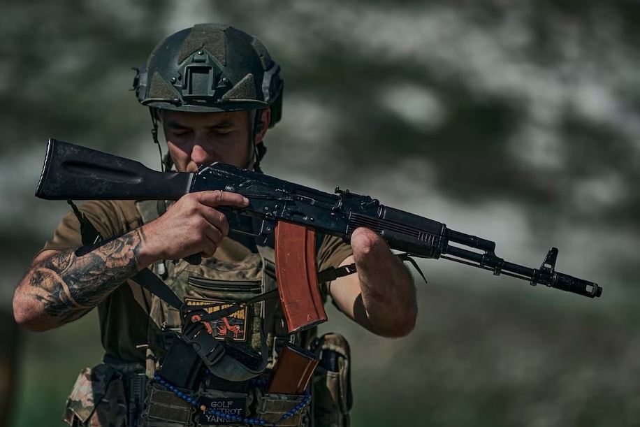 Một thương binh Ukraine tiếp tục cầm súng AK để chiến đấu. Ảnh: Washington Post.