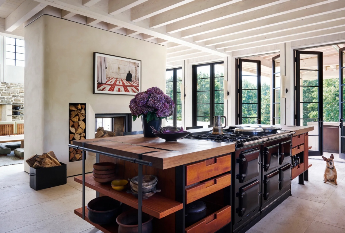 Nhà bếp kiểu trang trại hiện đại này được ví như trái tim của ngôi nhà nghỉ dưỡng màu hè của người dân nước Mỹ. Bên cạnh bàn bếp hiện đại, căn phòng vẫn giữ được những nét cổ điện với tranh tường và bó hoa được đặt ở giữa căn phòng.