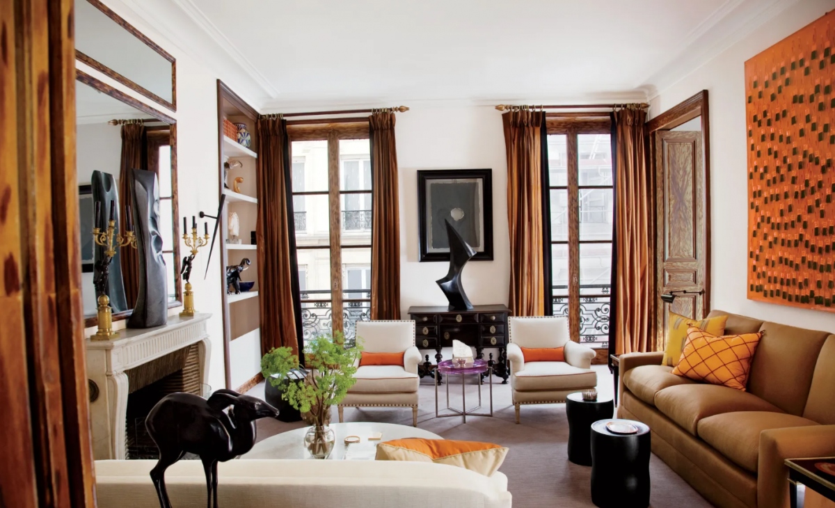 Kết hợp màu cam với màu nâu: Phòng khách mang phong cách Paris được trang trí với những cánh cửa gỗ ép, rèm lụa màu rượu vang và một cặp ghế bành màu nâu nhạt. Đây là sự kết hợp kiểu monochrome, rất phù hợp với những người yêu thích bảng màu ấm.