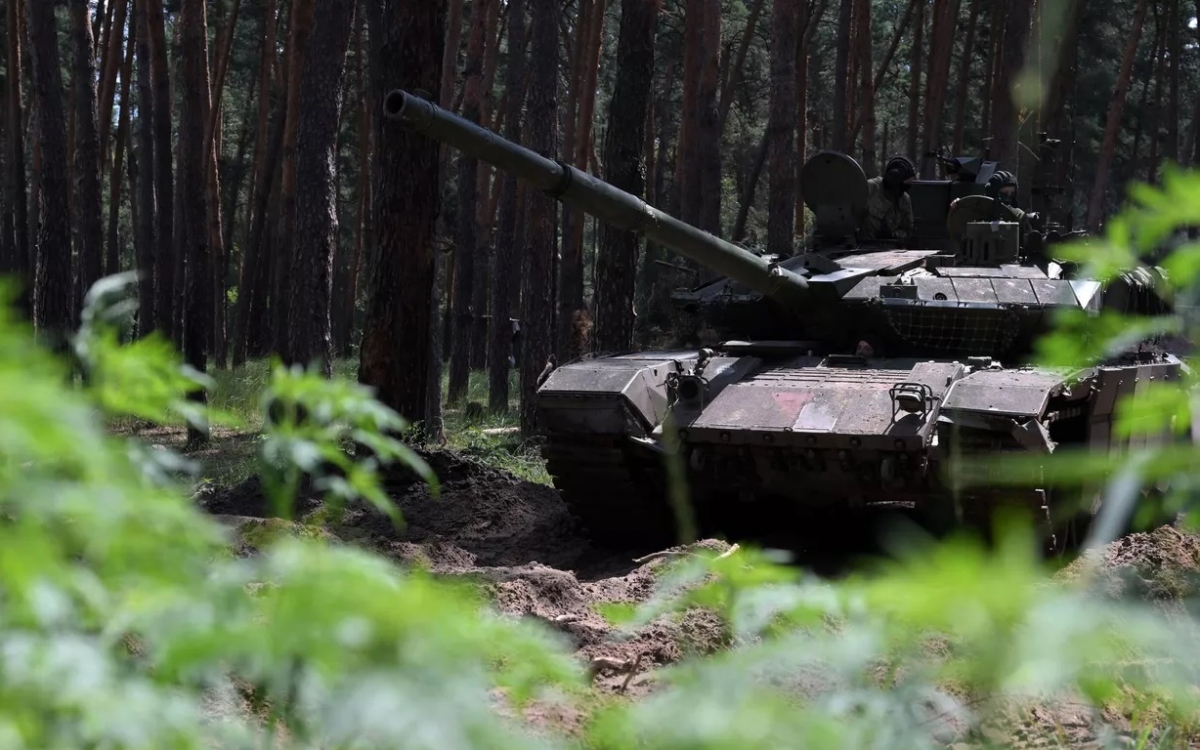 Một xe tăng T-90 ẩn trong rừng. Ảnh: Sputnik.