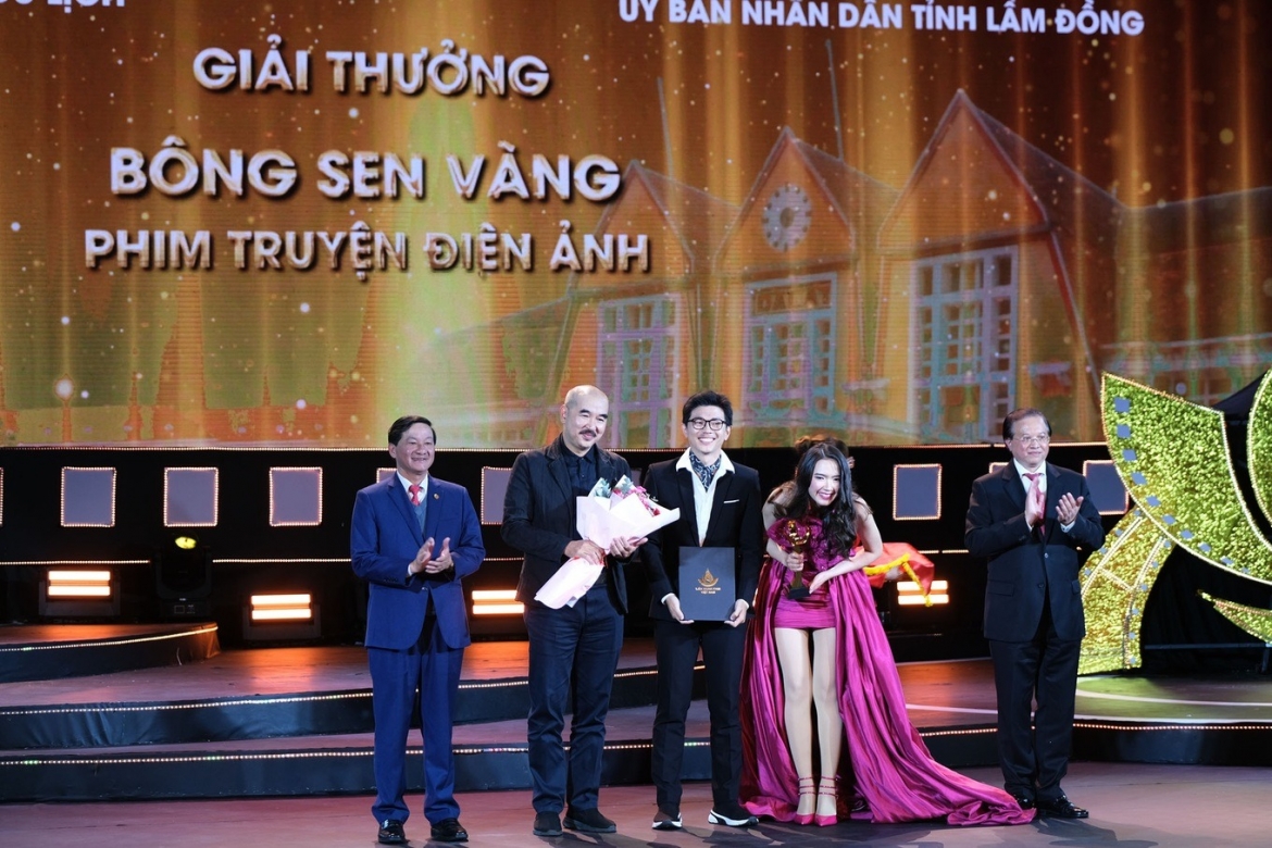 Đạo diễn Bùi Thạc Chuyên (cầm hoa) lên nhận giải Bông sen Vàng cho phim truyện điện ảnh (Ảnh: Mai Vinh).