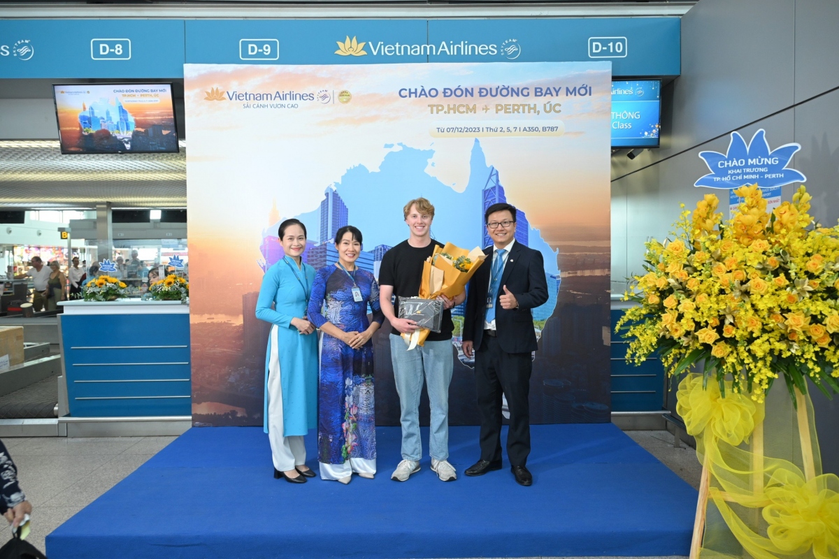 Các hành khách đi chuyến bay VN791 nhận hoa và quà lưu niệm của Vietnam Airlines