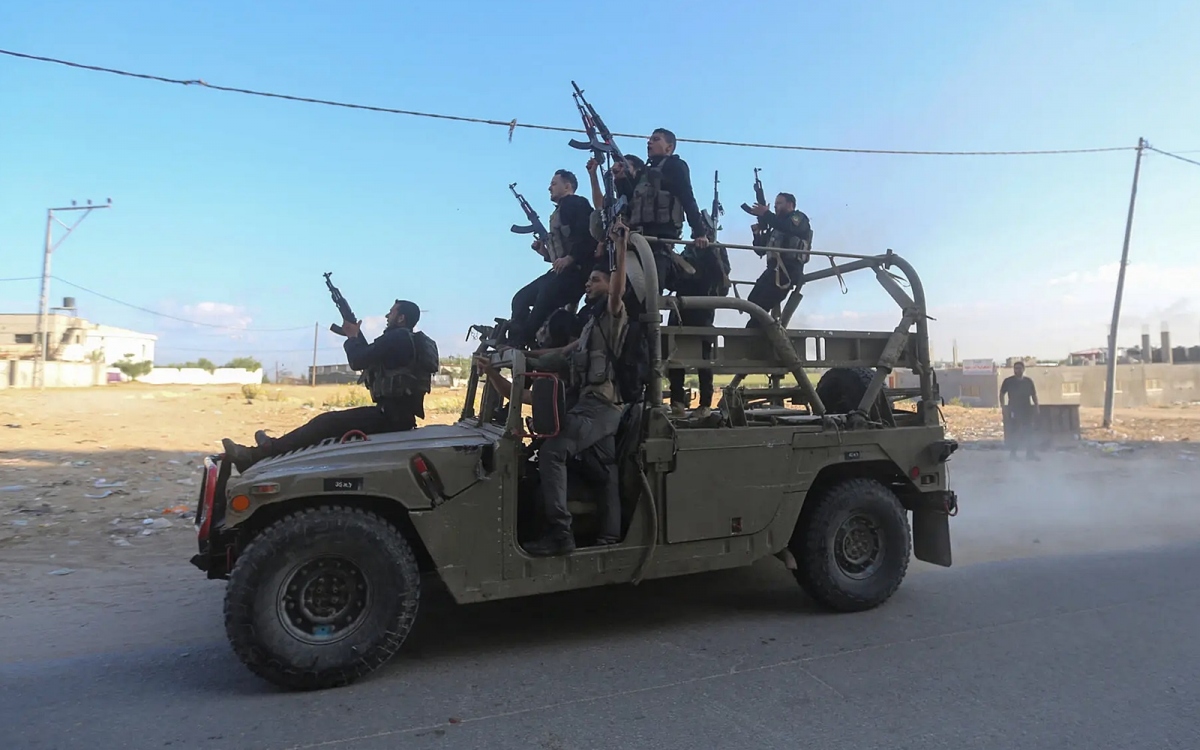 Các chiến binh Hamas chiếm một xe quân sự của Israel sau khi họ xâm nhập miền Nam Israel vào tháng 10/2023. Ảnh: Reuters.