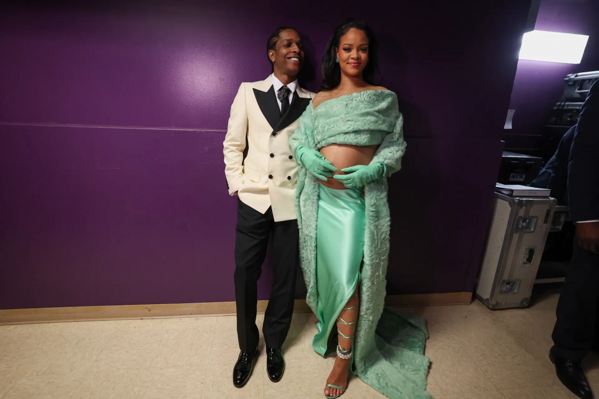 Sau màn trình diễn, Rihanna trở về chỗ ngồi với bộ trang phục đặt may riêng của Bottega Veneta. Bộ outfit màu xanh lá cây gồm áo choàng lông cừu lệch vai, váy lụa, găng tay da. Cô mang giày sandals của Area x Sergio Rossi. Trang phục này tiếp tục theo sát phong cách lộ bụng khi mang bầu của Rihanna.