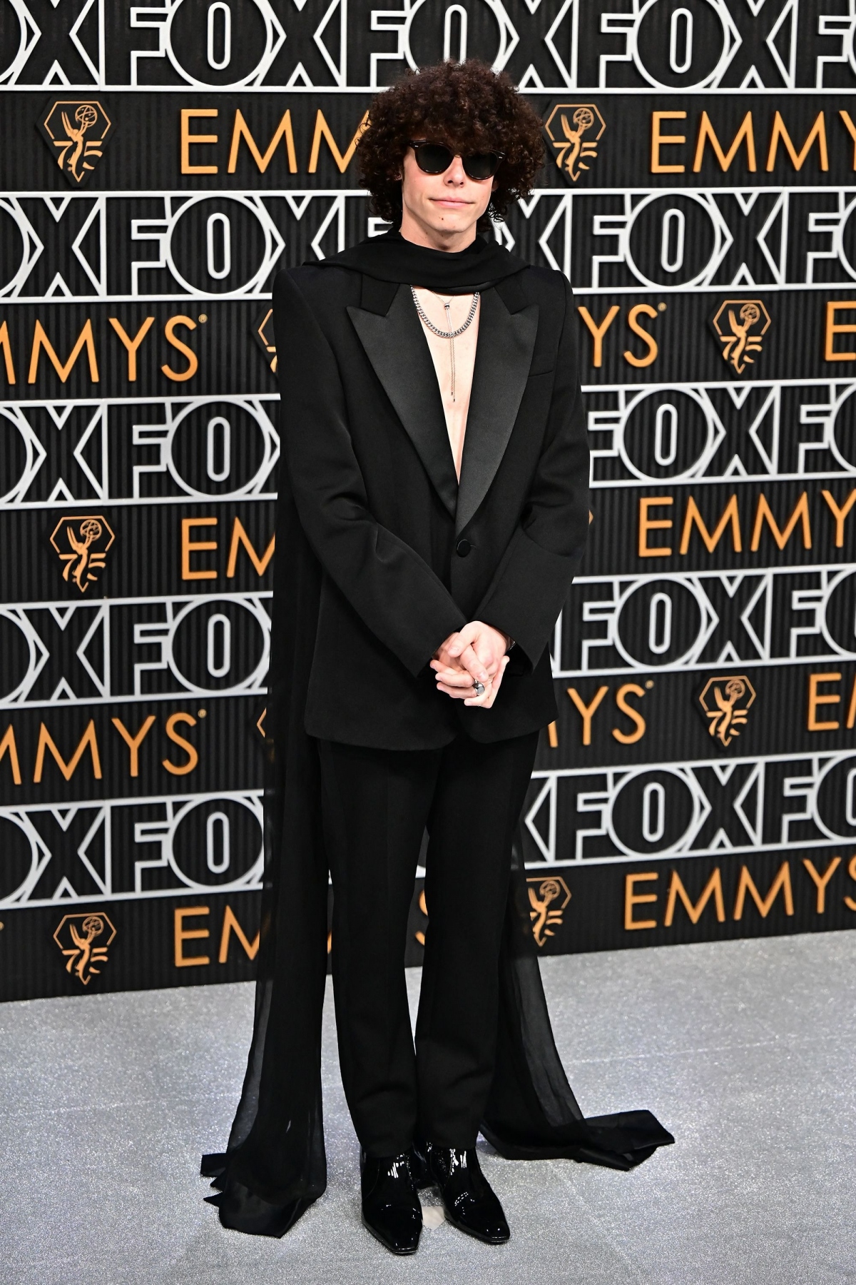 Mang hơi hướng rock quyến rũ, nam diễn viên Reece Feldman chọn cởi trần trong bộ tuxedo của Saint Laurent, kết hợp khăn quàng cổ màu đen và trang sức bạc.
