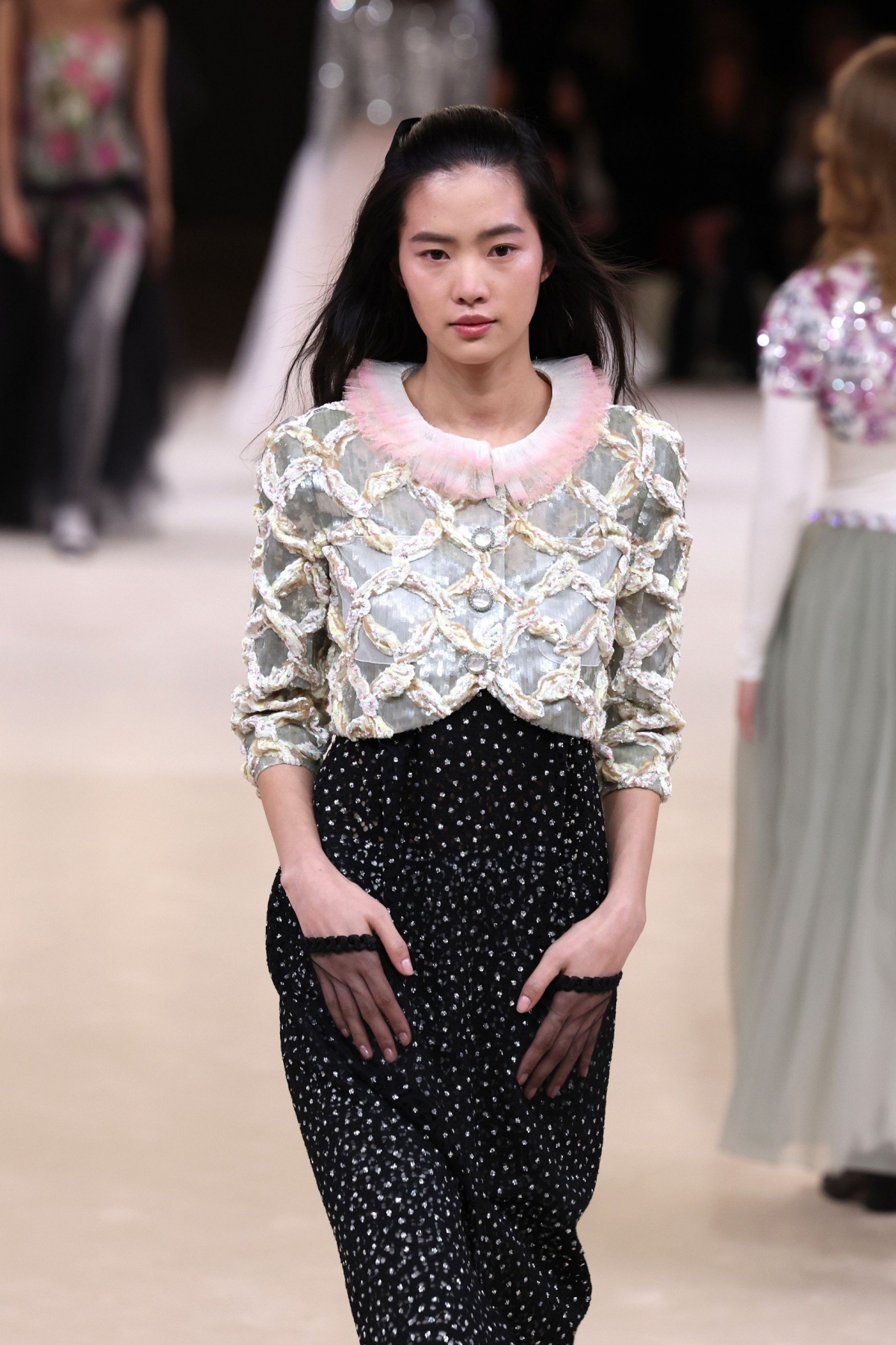 Buổi trình diễn của Chanel được mở đầu bởi Margaret Qualley rạng rỡ trong bộ trang phục toàn màu trắng với cổ áo kiểu xếp nếp.
