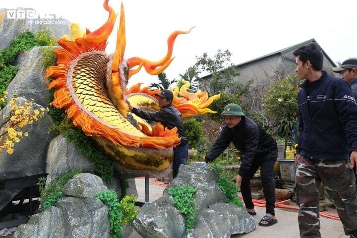 Nghệ nhân Đinh Văn Tâm cùng nhóm thợ chăm chút lại từng chi tiết trên linh vật rồng trước khi đưa lên thị trấn Lao Bảo trưng bày. (Ảnh: L.H.T)