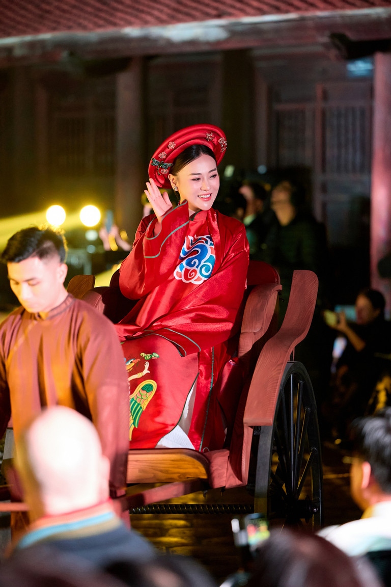 NTK Ngọc Hân mang tới chương trình nghệ thuật với chủ đề "Nơi tôi sinh ra" BST áo dài cảm hứng từ tranh Kim Hoàng, dòng tranh dân gian từng thất truyền một thời gian dài và hiện tại được các nghệ nhân phục dựng. Diễn viên Phương Oanh giữ vai trò vedette. Bà xã của Shark Bình đang mang bầu song thai ở tháng thứ 5 ngồi trên xe kéo xuất hiện trong bộ áo dài suông tông đỏ rực rỡ. Từ lúc kết hôn và thông báo tin vui sắp làm mẹ, đây là lần hiếm hoi nữ diễn viên xuất hiện trong một sự kiện showbiz. (Nguồn: VietNamNet)