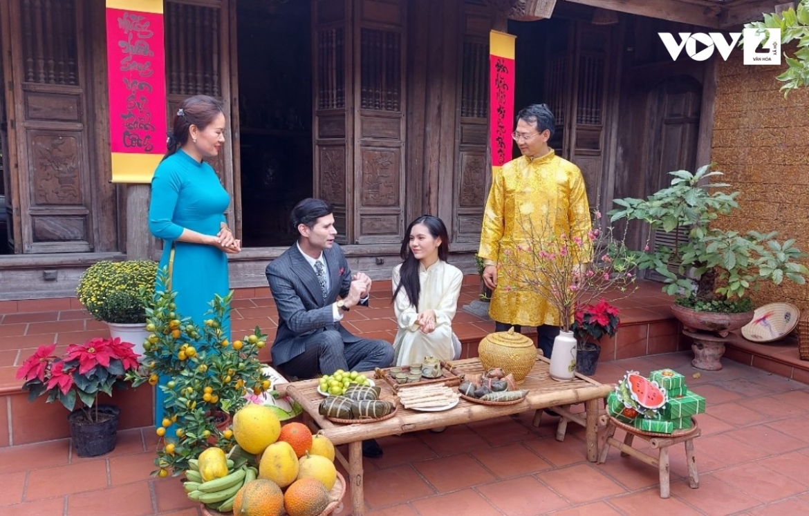 Diễn viên Charlie Win (thứ 2 từ trái sang) chụp ảnh cùng người dân và du khách trong không gian tái hiện Tết truyền thống tại Đường Lâm homestay