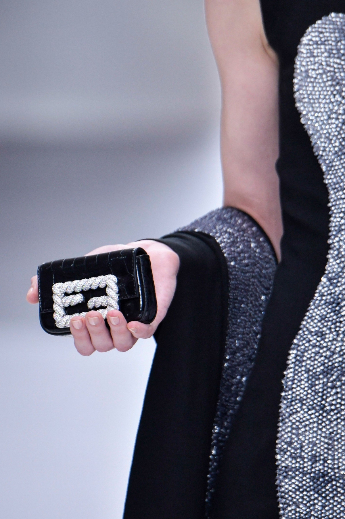Những chiếc túi Baguette mini của Fendi đã ra mắt lần đầu tiên với những chi tiết tinh xảo. Nói về trang trí, hãng đã chớp lấy thời cơ để ra mắt những chiếc túi “Gems Baguette” trên sàn catwalk, nổi bật với vàng trắng 18 cara, lá bạch kim và khóa nạm kim cương.