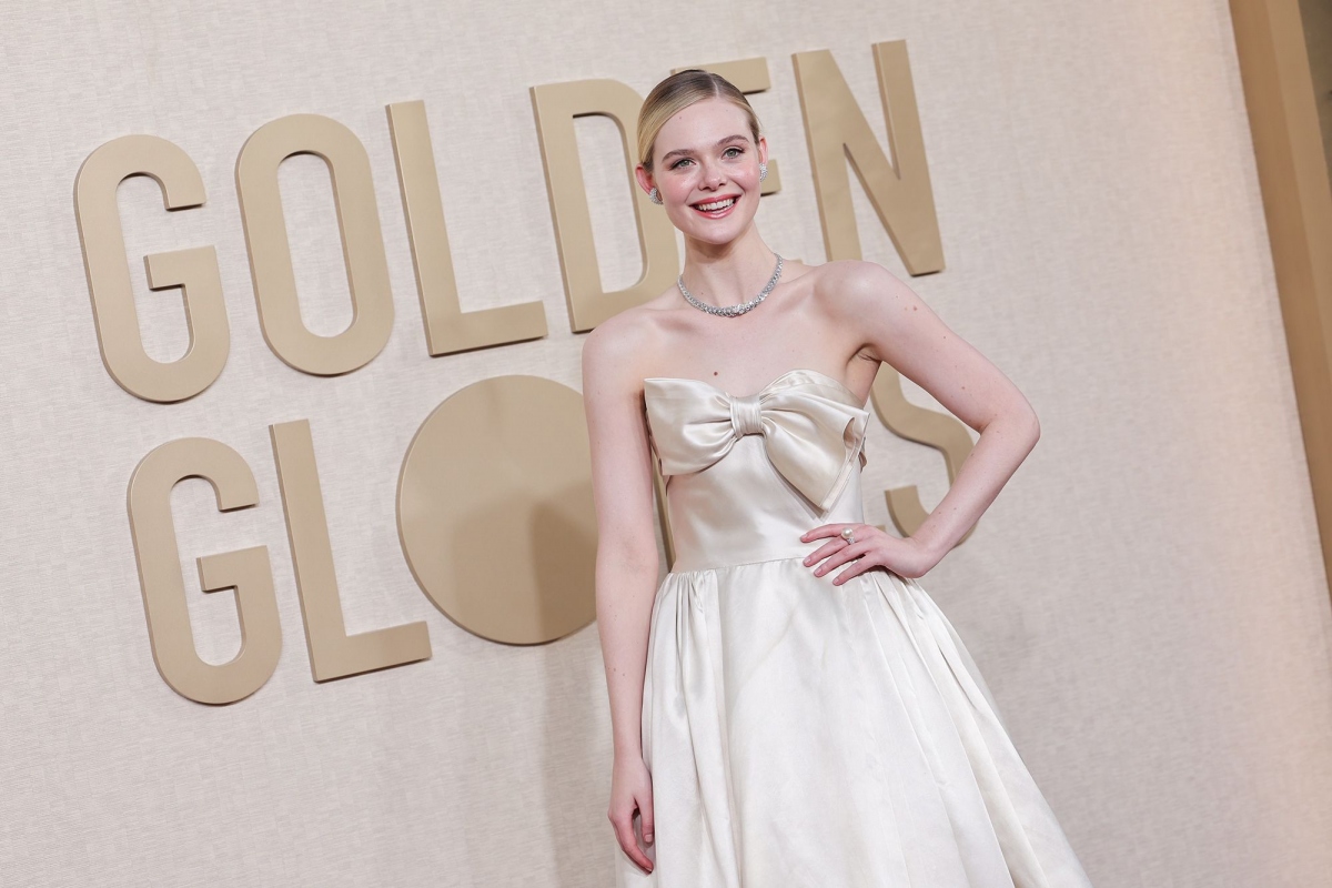 Elle Fanning chọn chiếc áo Pierre Balmain màu kem cổ điển đơn giản với chi tiết nơ cỡ lớn, trang sức Cartier và kiểu tóc búi cao.