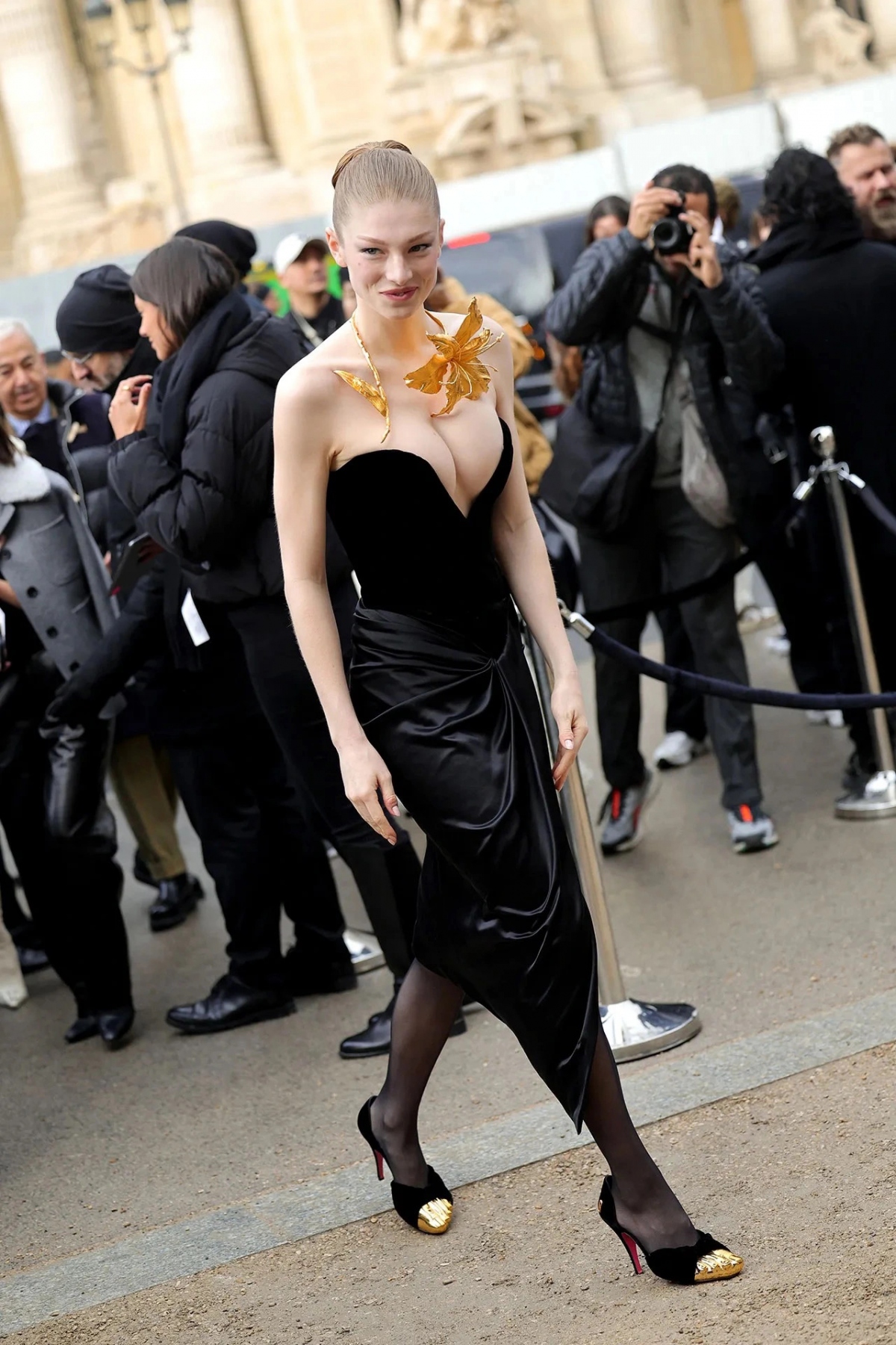 Hunter Schafer đã tạo được ấn tượng mạnh với tạo hình táo bạo cộp mác "Schiaparelli". 
Mỹ nhân chuyển giới diện một chiếc váy quây màu đen táo bạo, khoe khéo vòng 1 "bốc lửa"và tạo điểm nhấn với vòng cổ hoa ánh vàng nổi bật. Trong năm vừa qua, người đẹp "Euphoria" thường xuyên lọt top mặc đẹp của các tạp chí thời trang danh tiếng. Với outfit này, Hunter Schafer đã chiếm hết spotlight của dàn sao còn lại