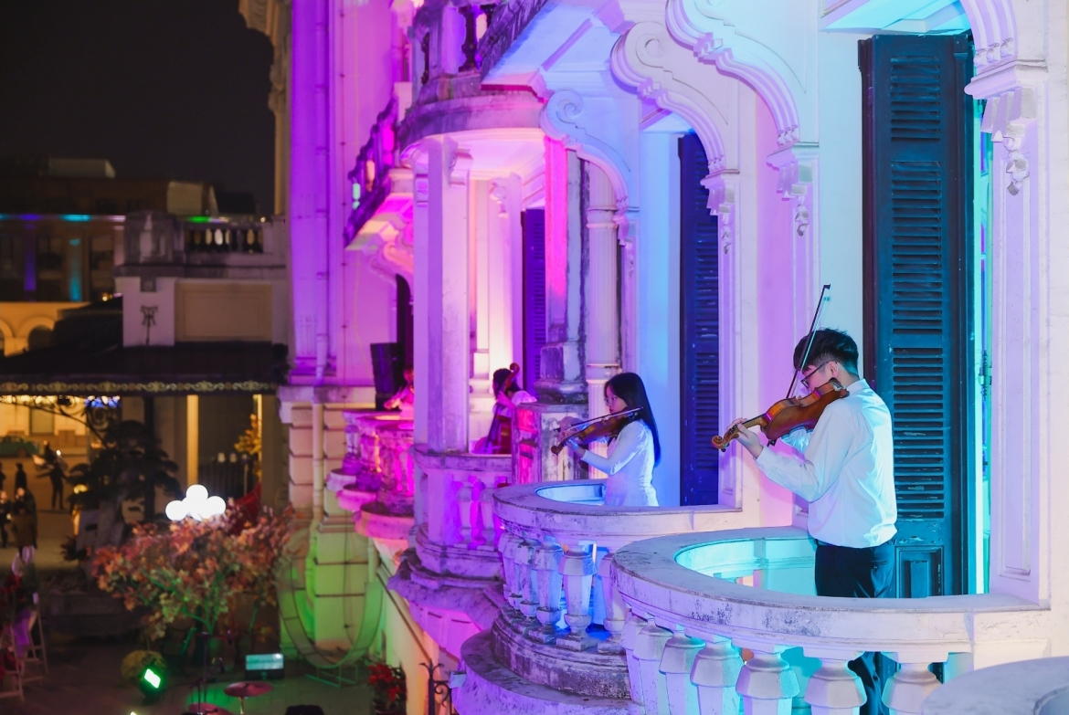 Nghệ sĩ chơi nhạc trên ban công Nhà hát Lớn Hà Nội, hướng ra phía khán giả của sân khấu ngoài trời