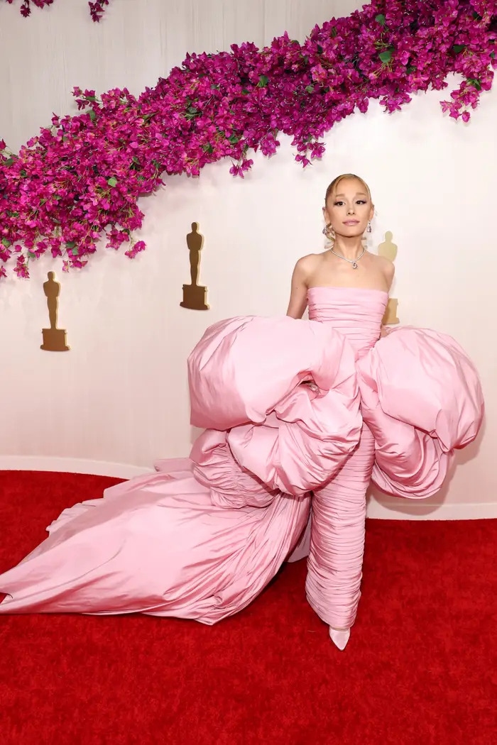 Chiếc váy Giambattista Valli do Grande thiết kế là sự gợi nhớ đến nhân vật Glinda của Ariana Grande trong bộ phim chuyển thể "Wicked" sắp tới. Nhưng chất liệu của chiếc váy khiến cô trông như đang mặc một chiếc túi ngủ trên thảm đỏ. Phần chân váy bó sát cũng khiến Grande có vẻ như gặp khó khăn khi đi lại.