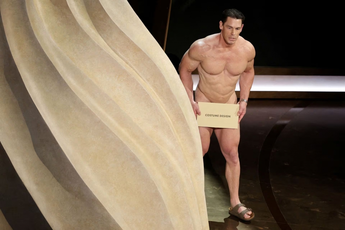 Cựu đô vật kiêm diễn viên John Cena gây sốc khi bước ra công bố giải Phục trang xuất sắc ở Oscar 2024. Anh không mặc quần áo, lấy phong bì đựng kết quả che vùng nhạy cảm. Khán giả cười ồ lên khi Cena không thể di chuyển phong bì để mở nó ra. Đây có thể coi là khoảnh khắc hài hước và gây sốc nhất trong mùa Oscar 2024. 