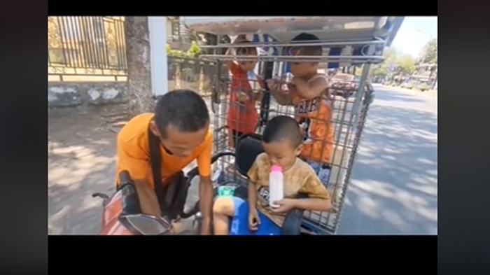 Người đàn ông chở cho con đi bán vé số dạo trên đường