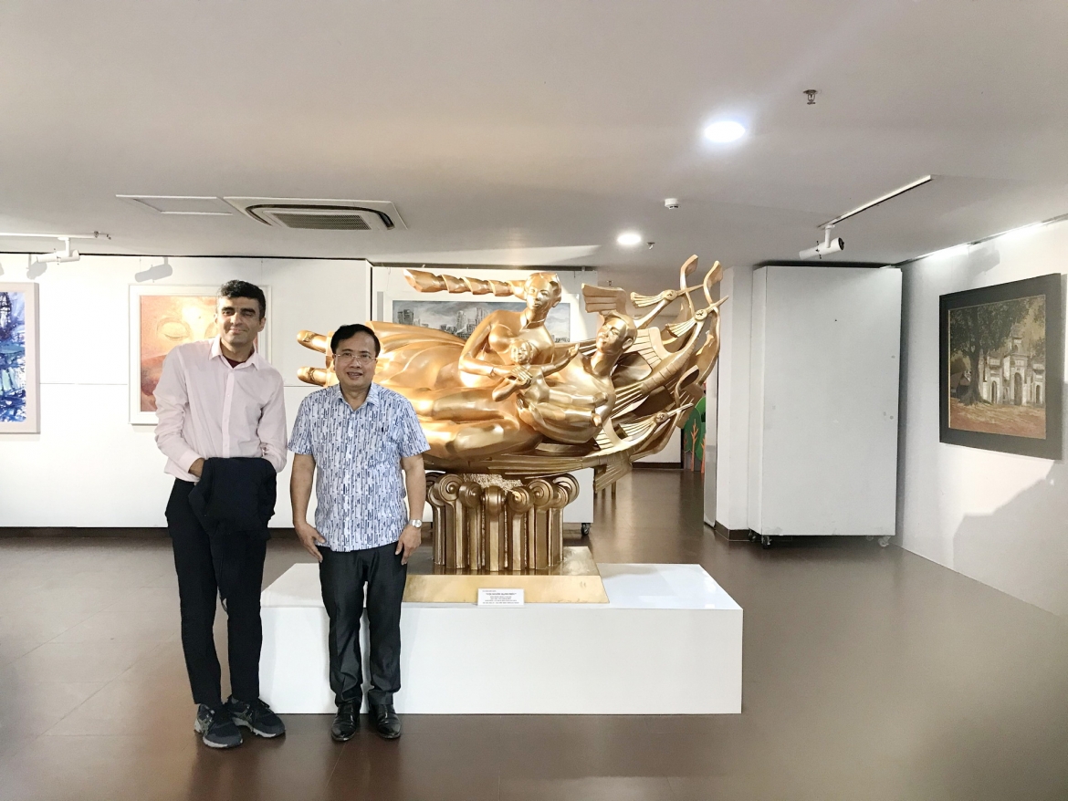 Họa sĩ Đinh Gia Thắng (bên phải) với tác phẩm điêu khắc “Cội nguồn hạnh phúc”. 