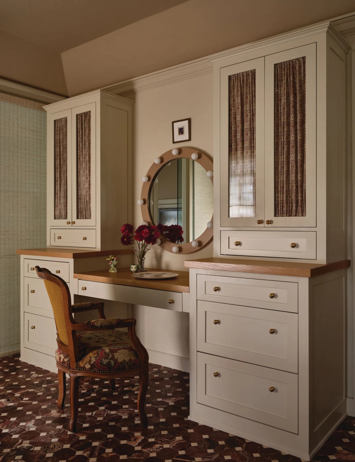 Phòng tắm chính có bàn trang điểm được thiết kế riêng được sơn màu Manchester Tan của Benjamin Moore . Gương tùy chỉnh; ghế kim cổ điển từ Chairish.