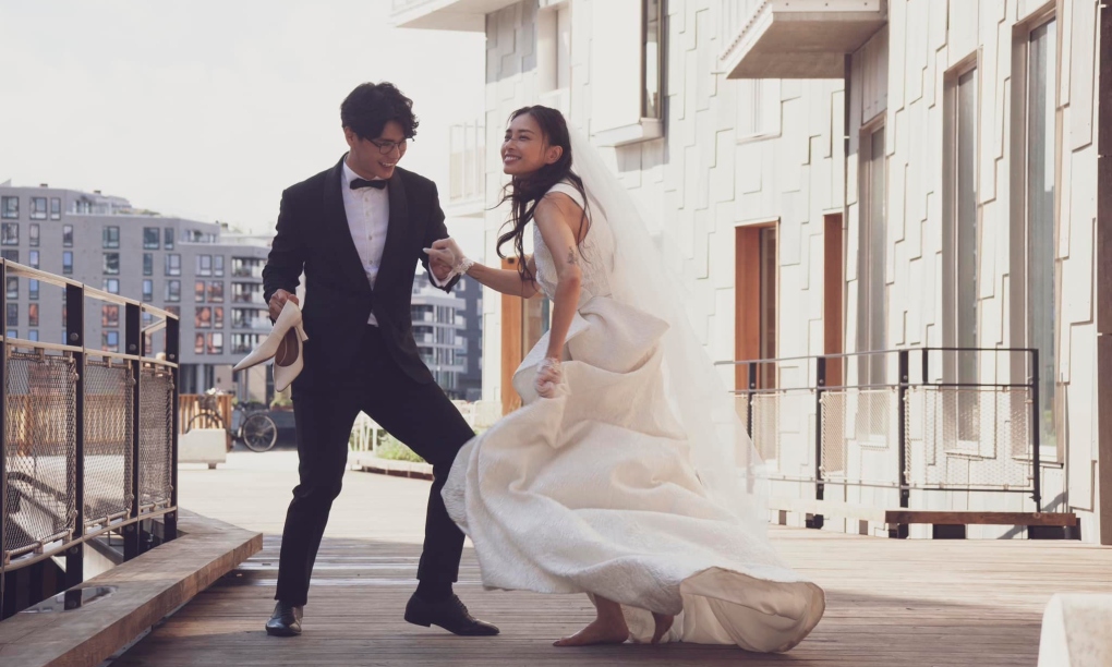 Kỷ niệm 2 năm ngày cưới, Ngô Thanh Vân hé lộ khoảnh khắc nhảy múa lãng mạn của vợ chồng trong trang phục cưới. Nữ diễn viên tay xách váy, đi chân trần, miệng cười rạng rỡ. Huy Trần nắm chặt tay cô, tay còn lại xách giày cho vợ.