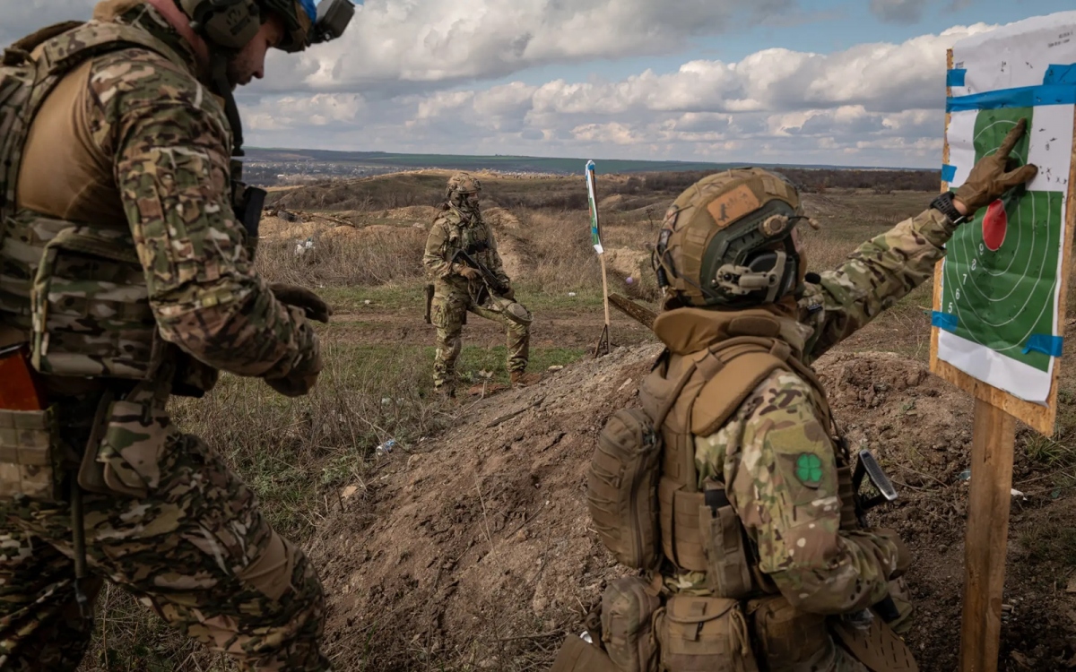 Mriya, 28 tuổi (phía sau) và Rys, 28 tuổi kiểm tra khu vực bia bắn trên thao trường.