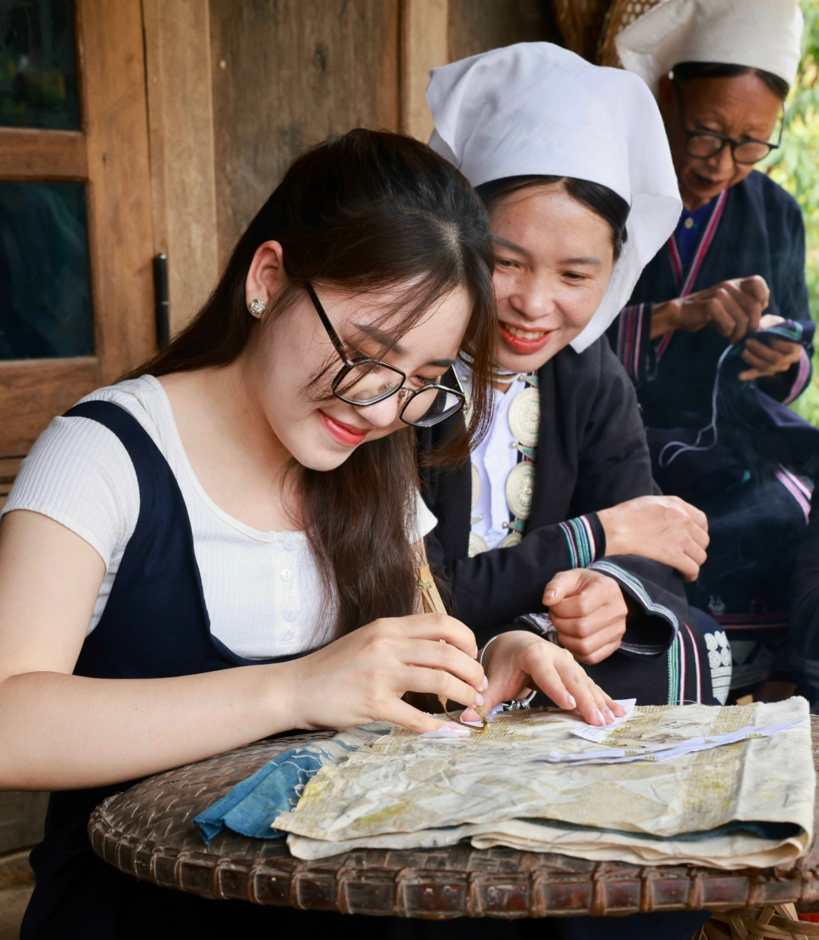 Du khách trải nghiệm thêu in hoa văn sáp ong. (Ảnh: Lê Hanh)