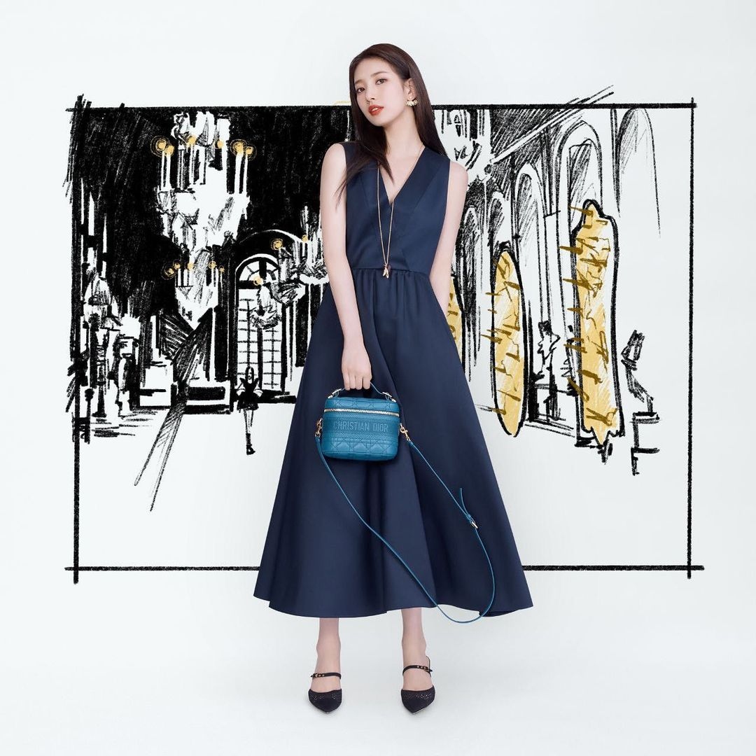 Điểm nhấn trong bộ sưu tập túi hiệu của Suzy không thể thiếu Small DiorTravel. Chiếc túi nhỏ xinh này tạo thêm màu sắc nổi bật, sang trọng nhưng cũng đầy phá cách cho bất kỳ bộ trang phục nào. Các chi tiết kim loại mạ vàng sáng bóng càng làm tăng thêm độ sang chảnh của Suzy khi mang theo chiếc túi. Small DiorTravel có giá khoảng 2.500 USD.