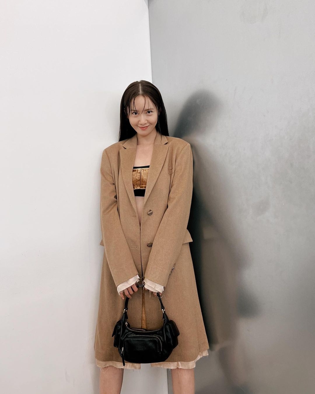 Yoona chọn kết hợp túi MiuMiu Multi Pocket màu đen với set trang phục màu trung tính gồm be, nâu. Túi xách có thiết kế rộng rãi, tiện dụng, làm bằng da, rất chắc chắn và không bị ăn mòn. MiuMiu Multi Pocket giúp nữ ca sĩ trở nên cá tính hơn. Chiếc túi có giá khoảng 2.700 USD. 