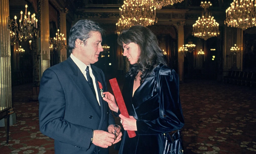 Vẻ ngoài điển trai và phong cách khác biệt của Alain Delon giúp ông tạo thiện cảm với các nhà sản xuất và có trong tay một số vai chính trong nhiều bộ phim của điện ảnh Pháp suốt thập niên 1960. Mặc dù có sự nghiệp thăng hoa, nhưng ông lại có đời tư tai tiếng khi vướng scandal đánh vợ con, ngoại tình, kỳ thị người đồng tính. Trong ảnh là Alain Delon và người mẫu Hà Lan Rosalie van Breemen. Hai người ở bên nhau từ năm 1987 - 2002.