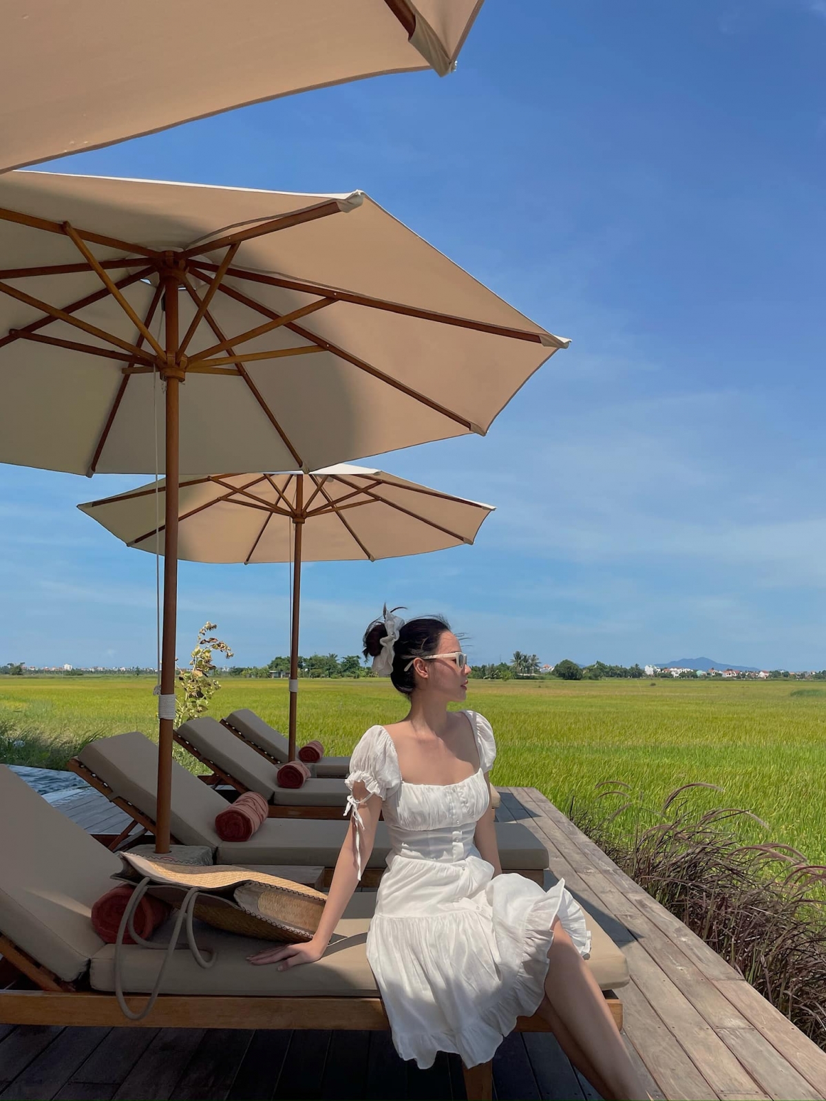 “Lâu lâu mới được ‘thở’. Chúc cả nhà có những khoảng trời nghỉ lễ cho riêng mình”, Midu tận hưởng kỳ nghỉ lễ. Cô diện đầm trắng nữ tính, ngồi ngắm cánh đồng xanh mướt bên khuôn viên một khu nghỉ dưỡng cao cấp. (Nguồn: FBNV)