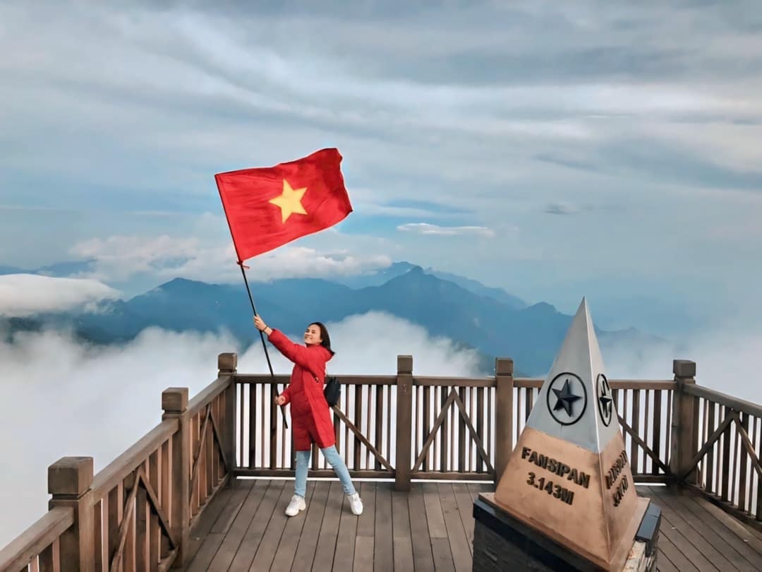 Diễn viên Thu Quỳnh đăng ảnh cầm cờ Việt Nam trên đỉnh Fansipan: “Việt Nam quê hương tôi đẹp lắm. Tôi tự hào vì được là một người con đất Việt”. (Nguồn: FBNV)