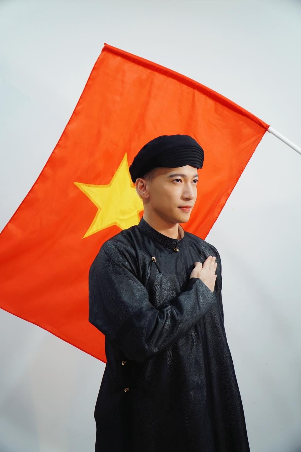 S.T Sơn Thạch đăng ảnh mặc áo dài bên cạnh nền cờ đỏ sao vàng. (Nguồn: FBNV)