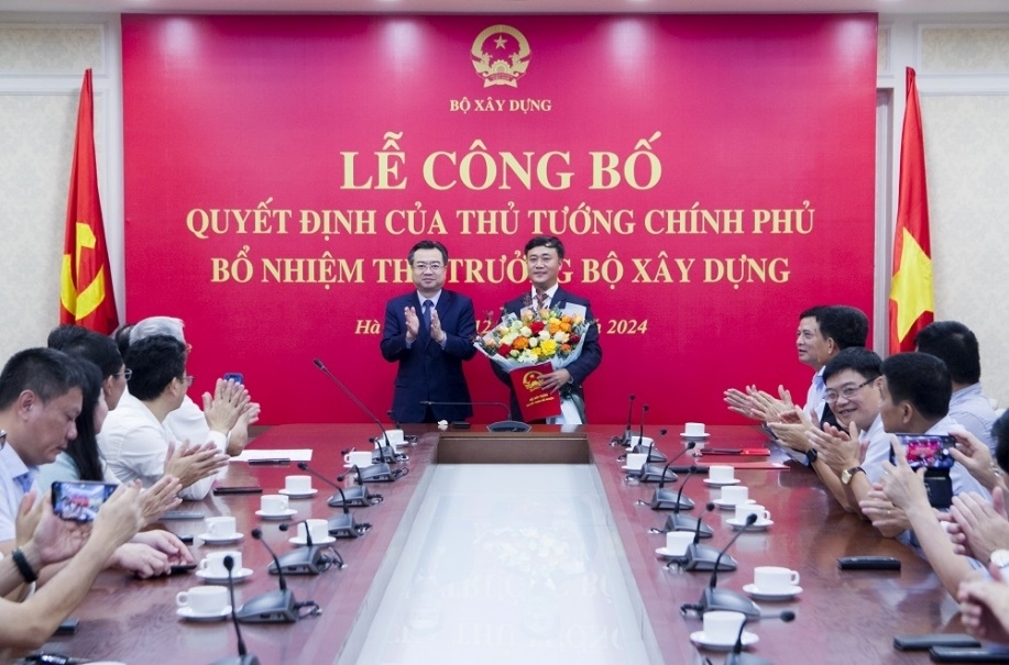 Bộ trưởng Nguyễn Thanh Nghị trao Quyết định bổ nhiệm và tặng hoa cho tân Thứ trưởng Bộ Xây dựng Nguyễn Việt Hùng.