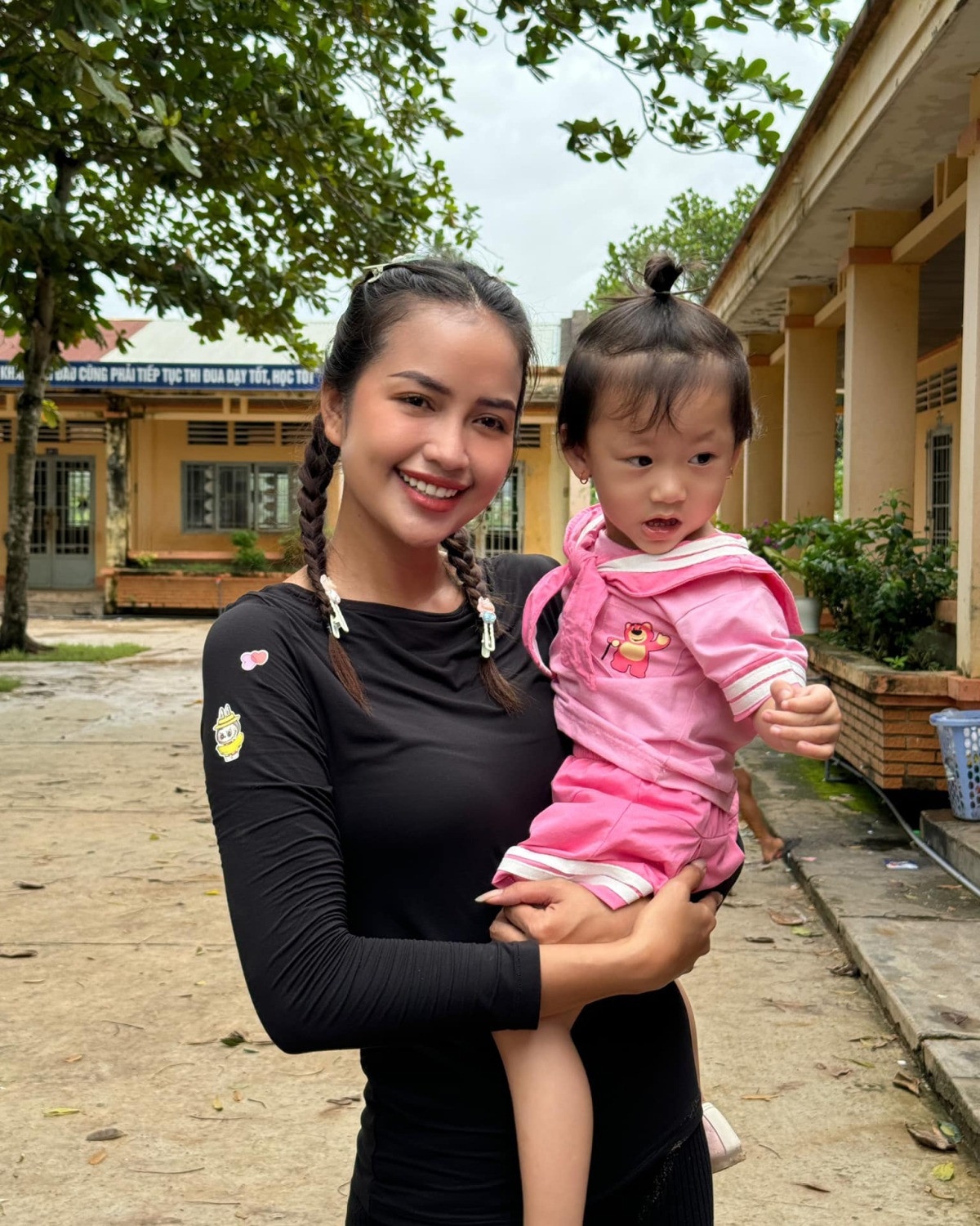 Hoa hậu Ngọc Châu bế em học sinh ở tiểu học Đồng Kèn, huyện Tân Châu, Tây Ninh. Người đẹp đang trong hành trình thực hiện dự án "Sân chơi Cầu Vồng" với sứ mệnh kiến tạo không gian chơi cộng đồng an toàn - sáng tạo cho trẻ em khắp Việt Nam.