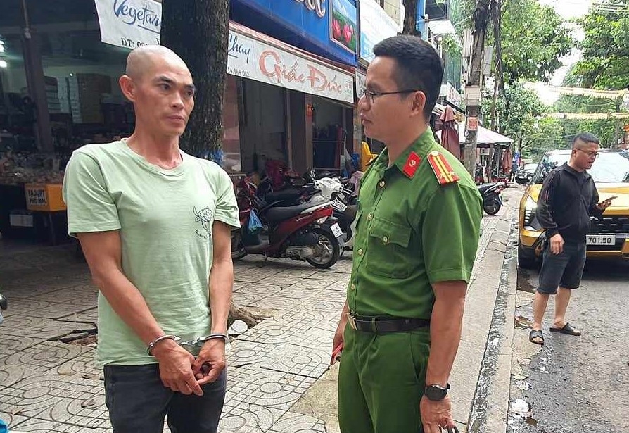 Thảo được công an dẫn giải tới hiện trường, nơi giật tập vé số của bà D.