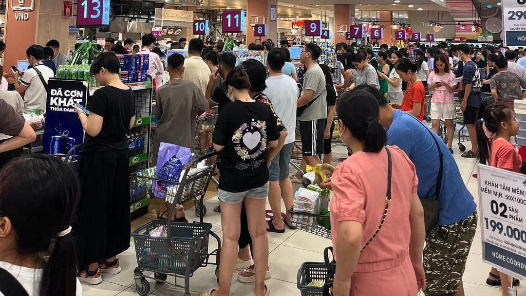Khách xếp đầy xe hàng với các mặt hàng thiết yếu chờ nhau thanh toán (Ảnh: KT)