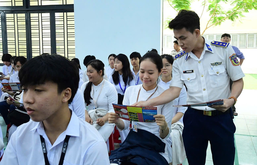 Cán bộ Cảnh sát biển tuyên truyền, phổ biến pháp luật bằng tờ rơi cho học sinh