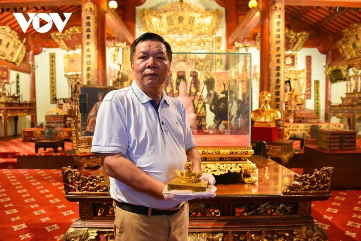 Doanh nhân Nguyễn Thế Hồng cầm trên tay ấn vàng Hoàng đế chi bảo trong gian phòng trưng bày