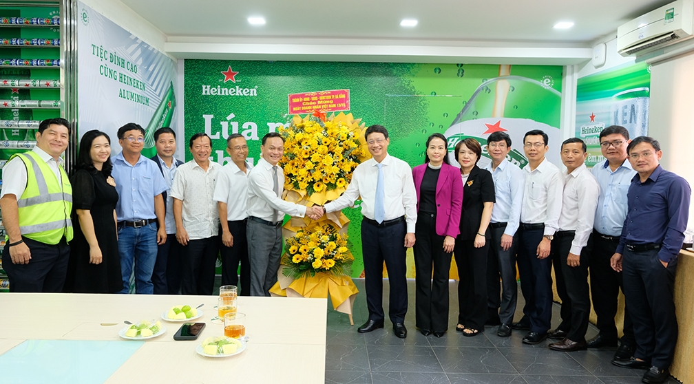 Ông Ngô Xuân Thắng, Chủ tịch HĐND thành phố Đà Nẵng (cà vạt xanh) tặng hoa chúc mừng cán bộ, nhân viên Nhà máy bia Heineken Việt Nam