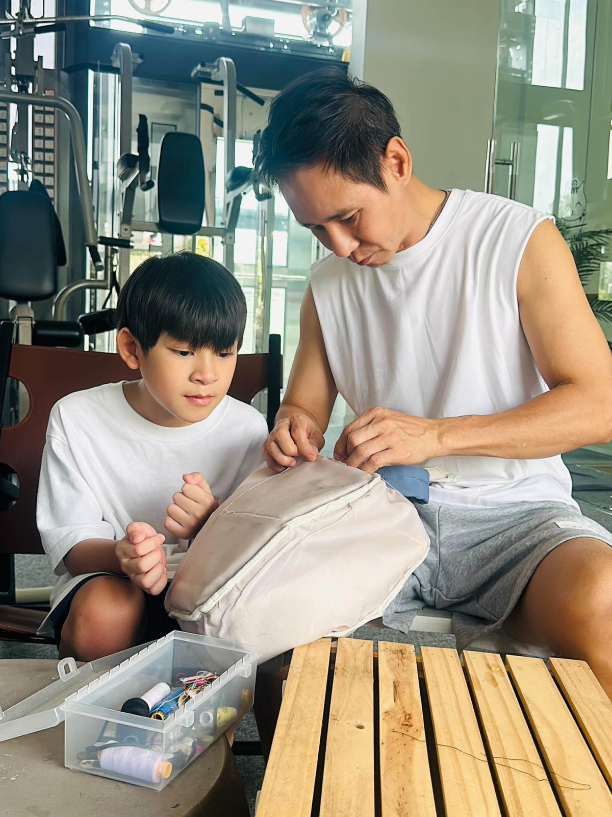 Minh Hà chụp lại khoảnh khắc ông xã Lý Hải cặm cụi sửa chiếc cặp cho con trai. "Ba của em không chỉ giỏi dọn dẹp nhà cửa mà còn có thể may vá", cô viết. (Nguồn: FBNV)