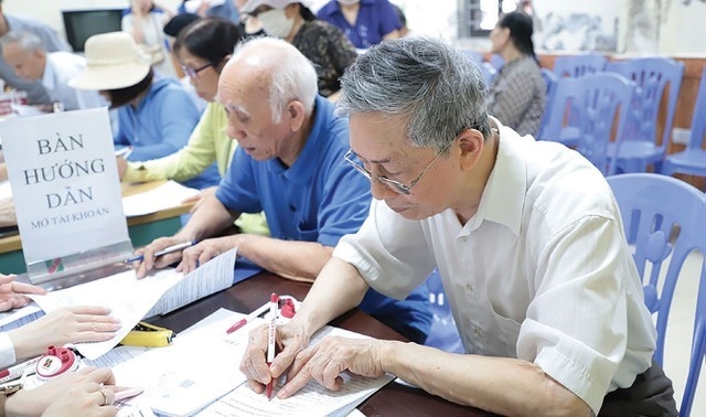 Cán bộ BHXH hướng dẫn người cao tuổi nhận lương hưu, trợ cấp BHXH qua các tài khoản cá nhân.