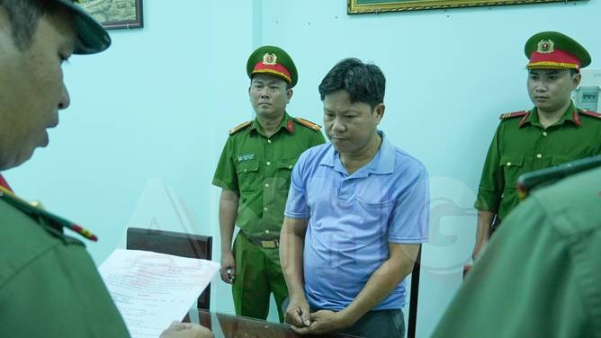 Cơ quan An ninh điều tra tống đạt quyết định khởi tố và lệnh bắt tạm giam Nguyễn Bảo Trung. Ảnh: Thế Phong