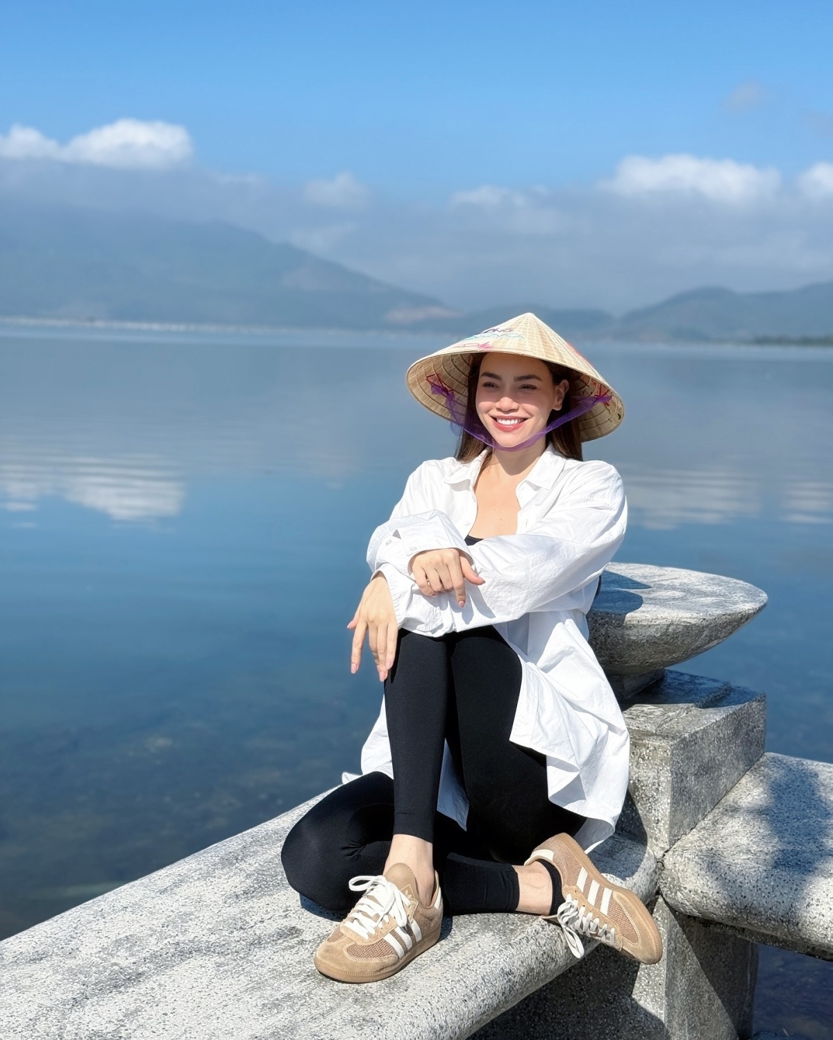 Hồ Ngọc Hà giản dị với áo sơ mi, quần dài, đội nón lá khoe vẻ rạng rỡ trong chuyến đi từ thiện đến Huế. (Nguồn: FBNV)