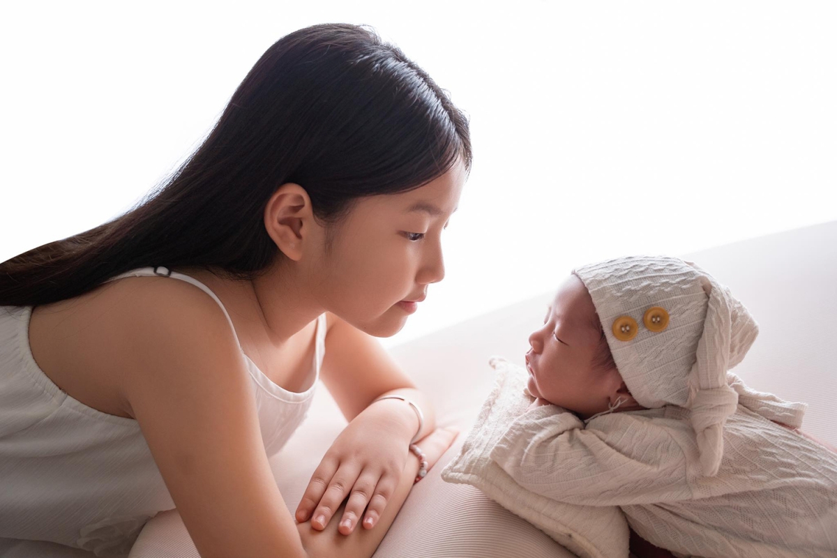 Tăng Khánh Chi - bạn gái nam diễn viên Quang Minh khoe khoảnh khắc con gái riêng 7 tuổi của cô chăm chú ngắm em trai. Cô gọi hai con là “hai cục kim cương”. (Nguồn: FBNV)