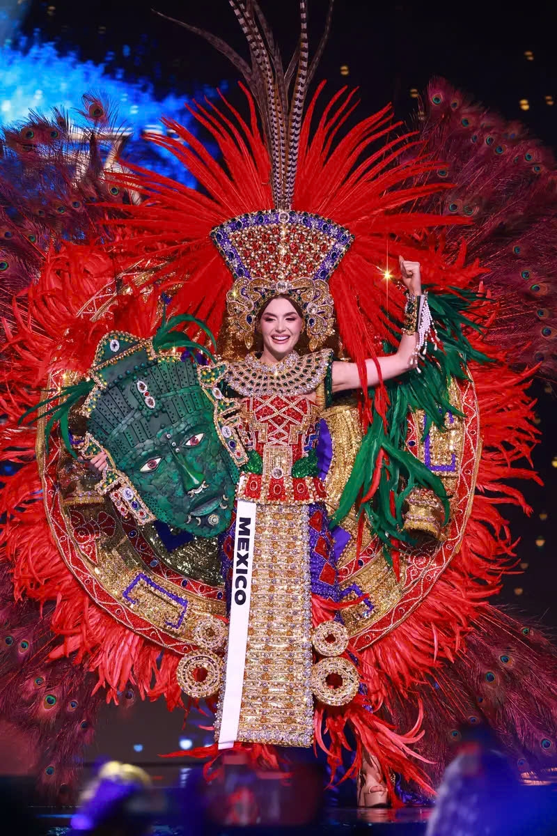 Hoa hậu Mexico, María Fernanda Beltrán Figueroa đã để bộ trang phục đầy màu sắc của mình trở thành tâm điểm chú ý. Người đẹp 24 tuổi đã sải bước lên sân khấu với khuôn mặt được che bởi một chiếc mặt nạ màu xanh lá cây khổng lồ.