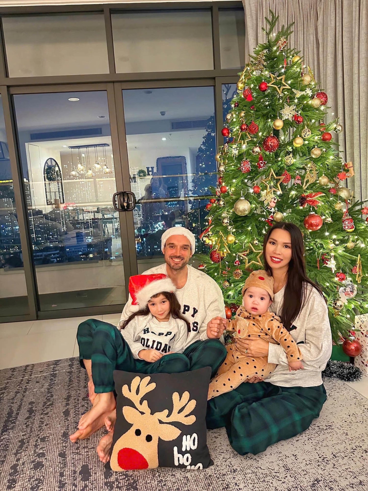 Gia đình siêu mẫu Hà Anh mặc đồ ngủ đồng điệu, quây quần bên cây thông Noel. (Nguồn: FBNV)