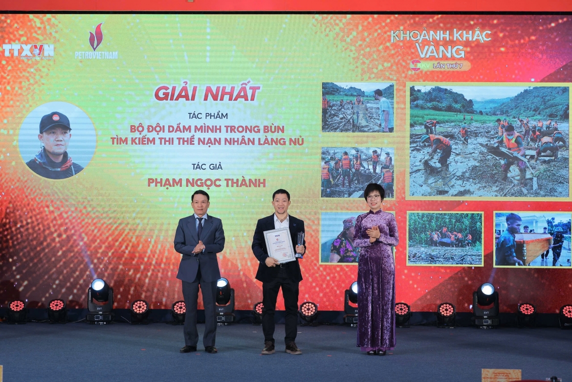 Tác giả Phạm Ngọc Thành (Hà Nội) nhận giải Nhất với tác phẩm ảnh bộ "Bộ đội dầm mình trong bùn tìm kiếm thi thể nạn nhân Làng Nủ". Ảnh: Hoàng Hiếu - TTXVN